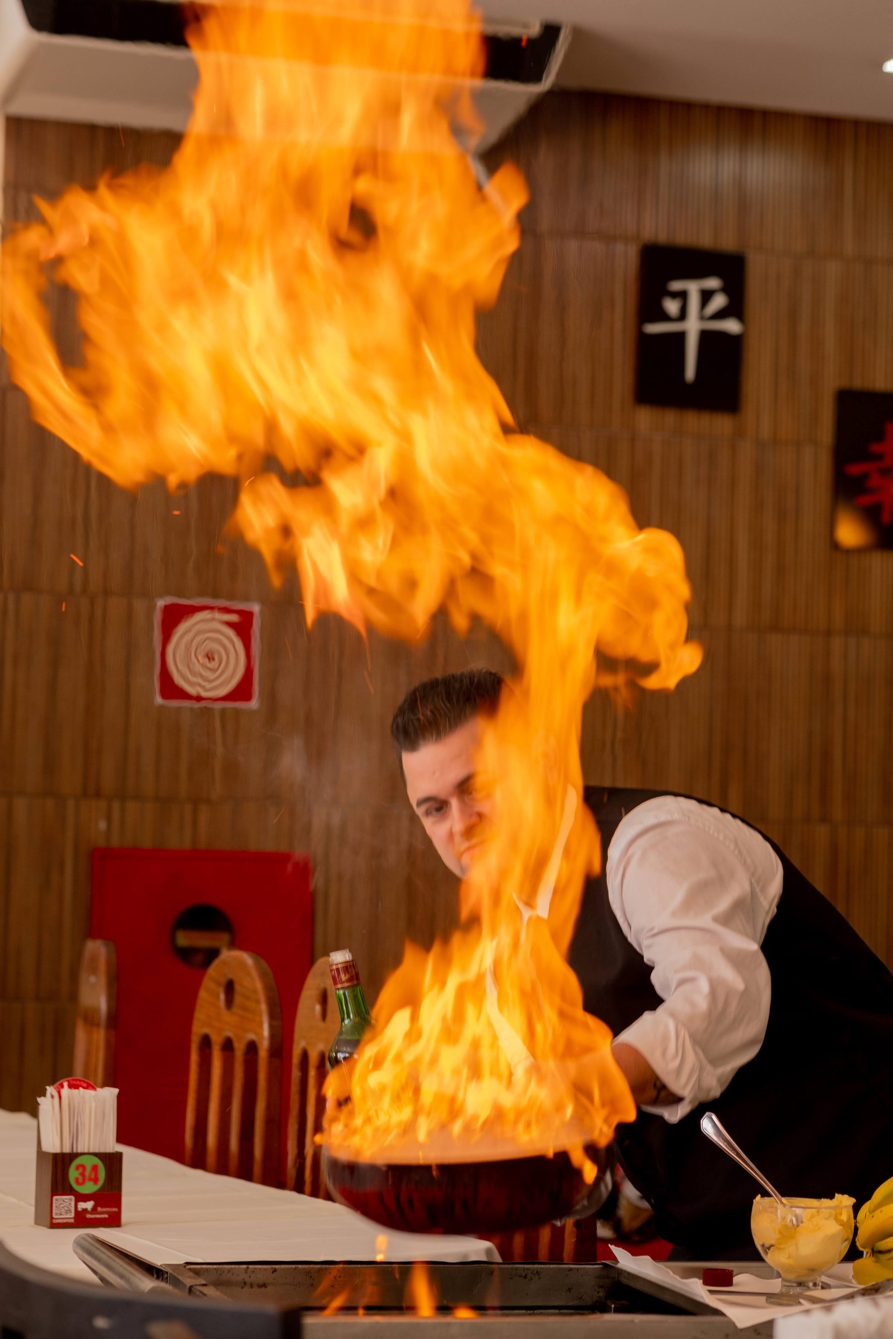 Chef preparando banana flambada em chamas no salão da Churrascaria Pampulha
